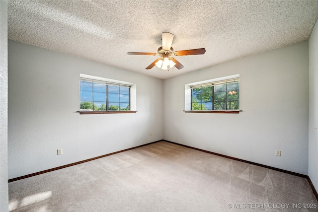 spare room featuring carpet flooring, ceiling fan, and baseboards