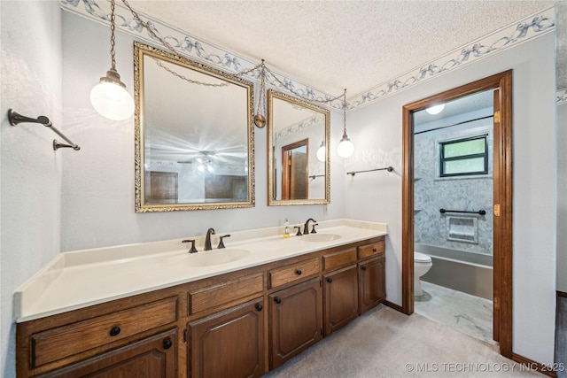 bathroom featuring toilet, a textured ceiling, double vanity, and a bathtub