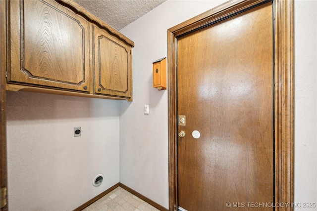 laundry room featuring hookup for an electric dryer, baseboards, and cabinet space
