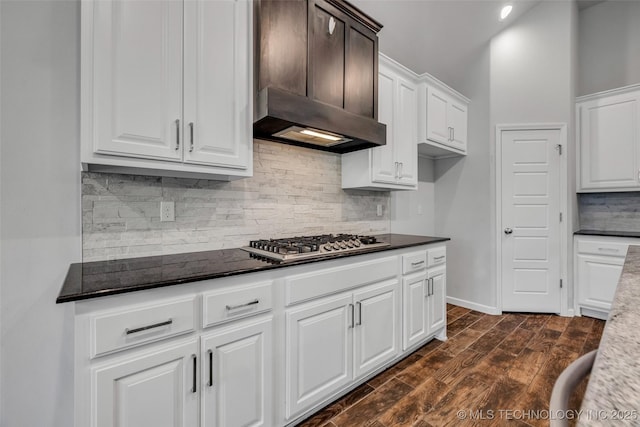 kitchen featuring stainless steel gas cooktop, decorative backsplash, dark wood-style floors, and white cabinets