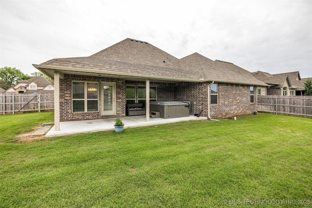 rear view of property with a hot tub, a patio area, brick siding, and roof with shingles