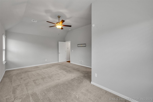 carpeted empty room featuring a ceiling fan, lofted ceiling, and baseboards