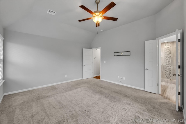 unfurnished bedroom featuring lofted ceiling, carpet floors, baseboards, ceiling fan, and ensuite bath