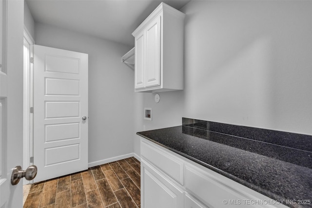 washroom featuring cabinet space, hookup for a washing machine, wood finish floors, and baseboards