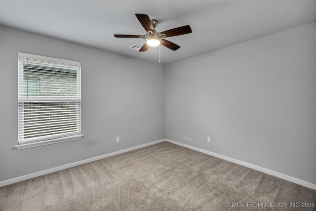 carpeted spare room featuring plenty of natural light, baseboards, and ceiling fan