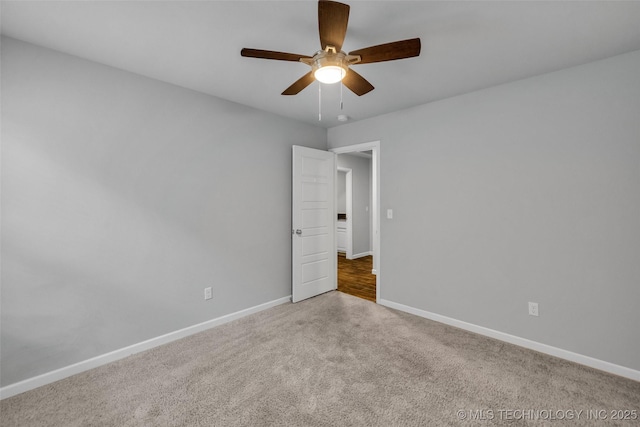 unfurnished room with carpet, a ceiling fan, and baseboards