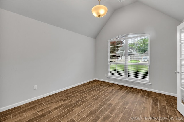 empty room with dark wood-style flooring, baseboards, and vaulted ceiling