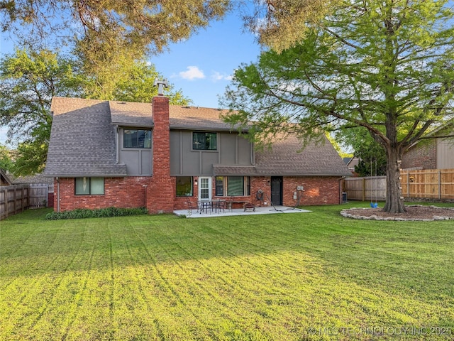 back of property featuring a patio area, a chimney, brick siding, and a shingled roof