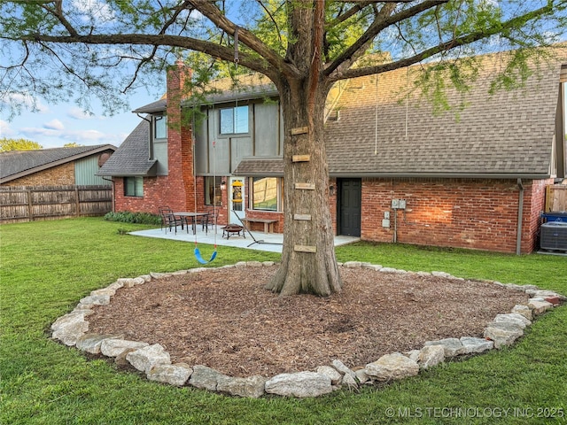 rear view of property with roof with shingles, a chimney, brick siding, a patio, and central air condition unit