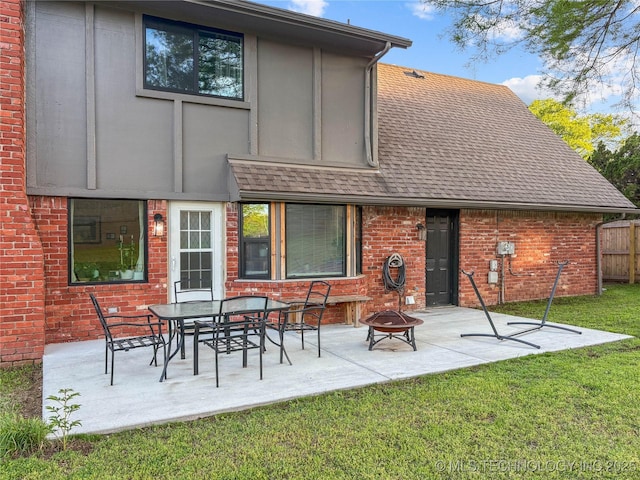 back of house with a fire pit, brick siding, a patio area, and a shingled roof