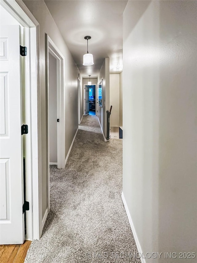 corridor featuring an upstairs landing, baseboards, and carpet flooring