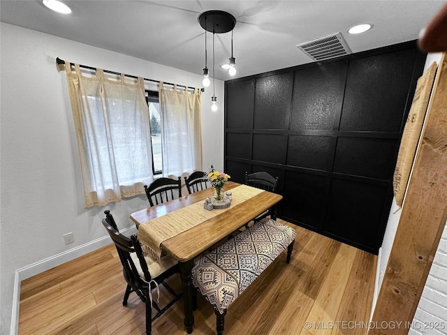 dining room featuring light wood-type flooring and baseboards