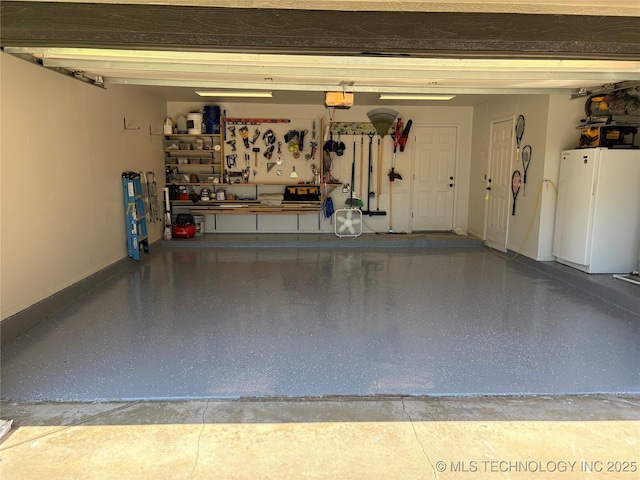 garage with freestanding refrigerator, a garage door opener, baseboards, and a workshop area