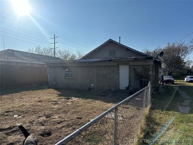view of side of home featuring fence