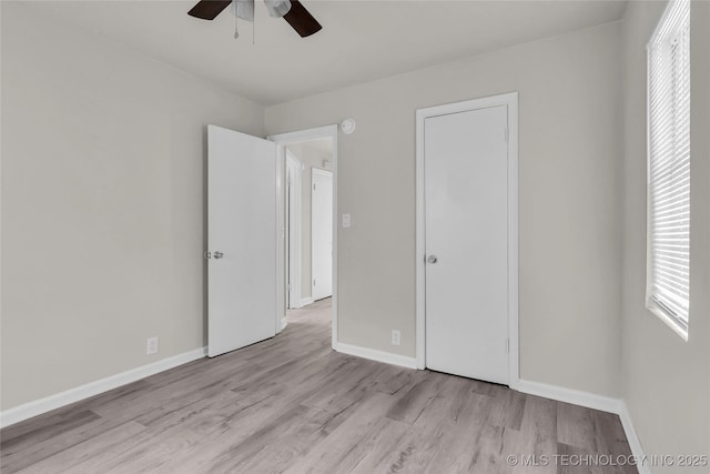 unfurnished bedroom with wood finished floors, baseboards, and ceiling fan