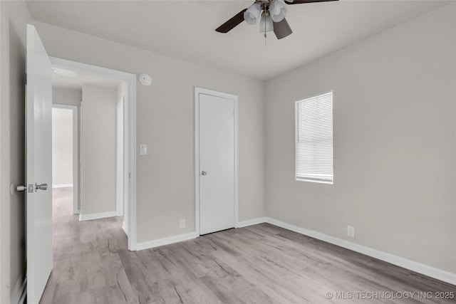 unfurnished bedroom with wood finished floors, baseboards, and ceiling fan