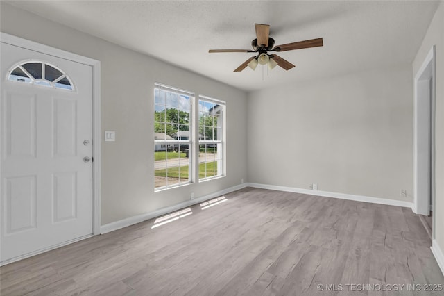 entrance foyer with a ceiling fan, wood finished floors, and baseboards
