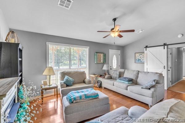 10718 W 162nd St, Skiatook, OK 74070 - living room with a barn door, a ceiling fan, wood finished floors, and lofted ceiling