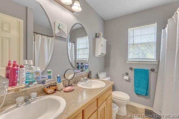10718 W 162nd St, Skiatook, OK 74070 - bathroom with toilet, double vanity, tile patterned flooring, and baseboards