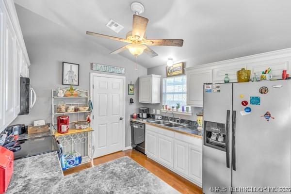 10718 W 162nd St, Skiatook, OK 74070 - kitchen featuring black appliances, a sink, ceiling fan, white cabinets, and vaulted ceiling