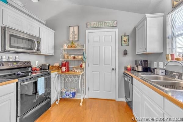 10718 W 162nd St, Skiatook, OK 74070 - kitchen featuring stainless steel appliances, a sink, light wood-style flooring, white cabinetry, and lofted ceiling