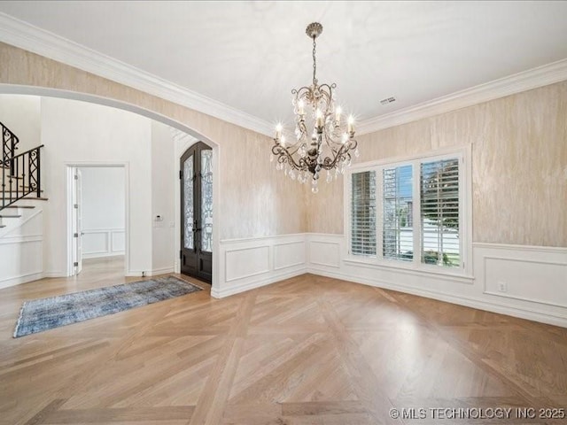 4301 S Mimosa Ave, Broken Arrow, OK 74011 - unfurnished dining area with arched walkways, stairs, a chandelier, crown molding, and a decorative wall