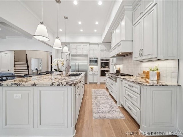 4301 S Mimosa Ave, Broken Arrow, OK 74011 - kitchen with built in appliances, a sink, light wood-style floors, white cabinets, and crown molding