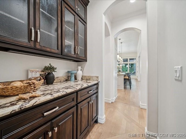 4301 S Mimosa Ave, Broken Arrow, OK 74011 - bar featuring arched walkways, crown molding, baseboards, and light wood-style floors