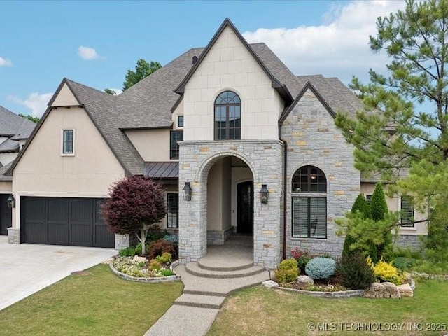 4301 S Mimosa Ave, Broken Arrow, OK 74011 - french country home with stone siding, roof with shingles, a front lawn, concrete driveway, and a standing seam roof