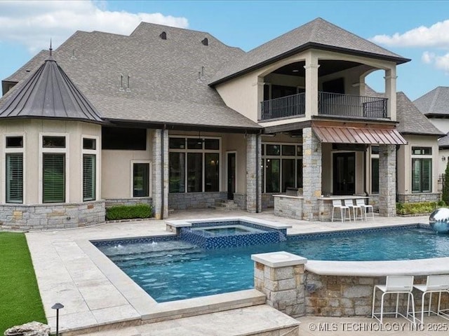 4301 S Mimosa Ave, Broken Arrow, OK 74011 - rear view of house with a balcony, stone siding, a patio area, stucco siding, and a standing seam roof