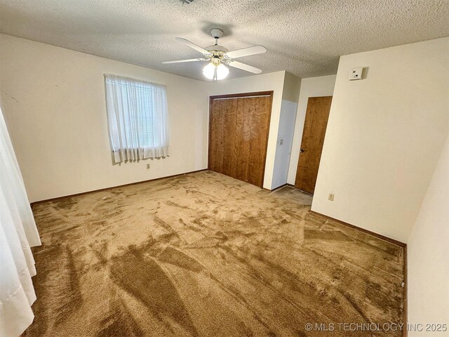 unfurnished bedroom with carpet floors, ceiling fan, and a textured ceiling