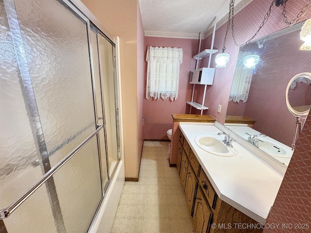 bathroom with tile patterned floors, a shower with door, a textured ceiling, toilet, and vanity