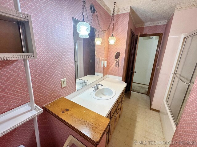 full bath with tile patterned floors, wallpapered walls, vanity, a textured ceiling, and shower / bath combination with glass door