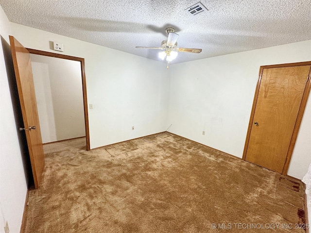 unfurnished bedroom with carpet floors, a textured ceiling, and ceiling fan