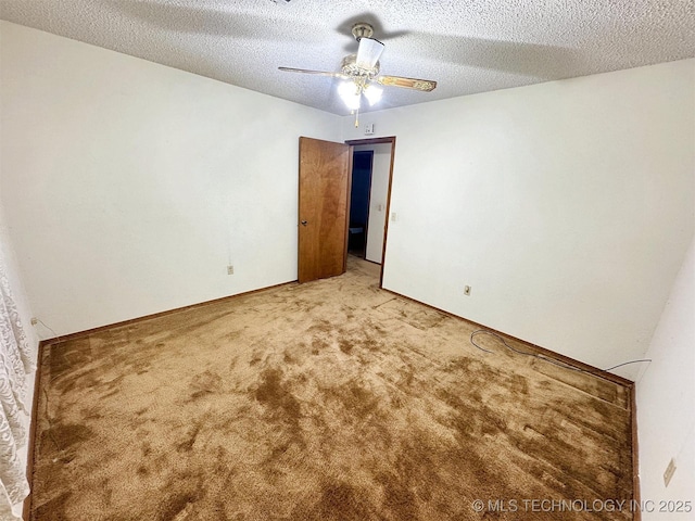 carpeted empty room with ceiling fan, a textured ceiling, and baseboards