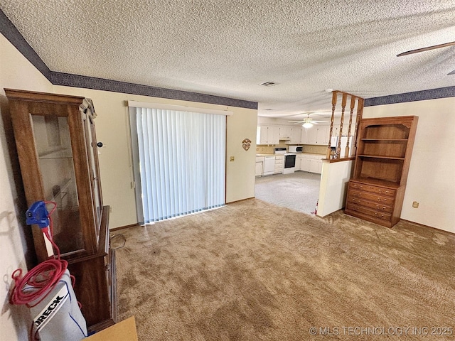 unfurnished living room with ceiling fan, light colored carpet, and a textured ceiling