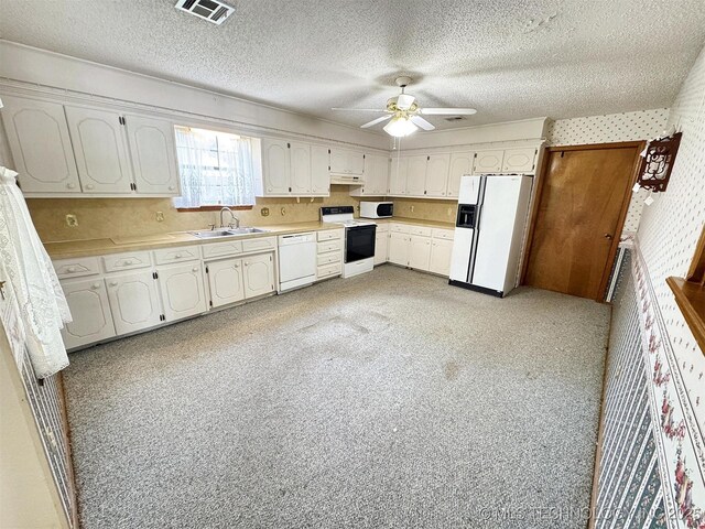 kitchen featuring white appliances, under cabinet range hood, a sink, a ceiling fan, and light countertops