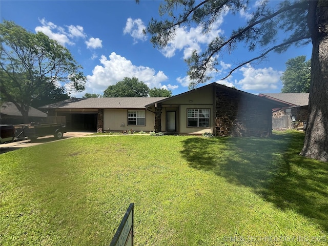 14139 E 26th St, Tulsa, OK 74134 - rear view of house featuring an attached garage, a lawn, and stone siding