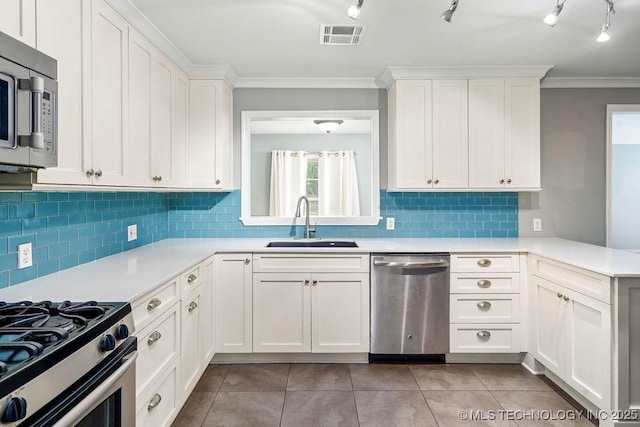 kitchen featuring appliances with stainless steel finishes, a sink, light countertops, crown molding, and white cabinets