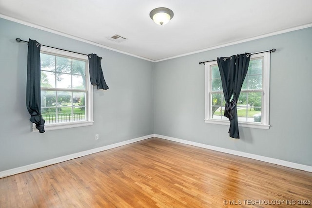 unfurnished room featuring baseboards, wood finished floors, and ornamental molding