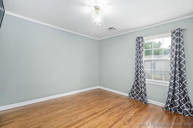 unfurnished room featuring wood finished floors, baseboards, and ornamental molding