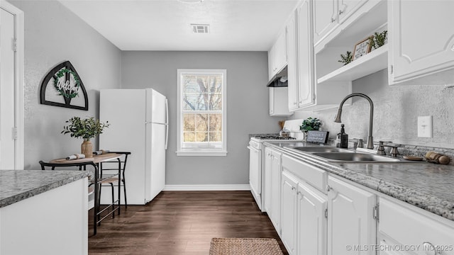 kitchen with white appliances, a sink, under cabinet range hood, dark wood-type flooring, and open shelves