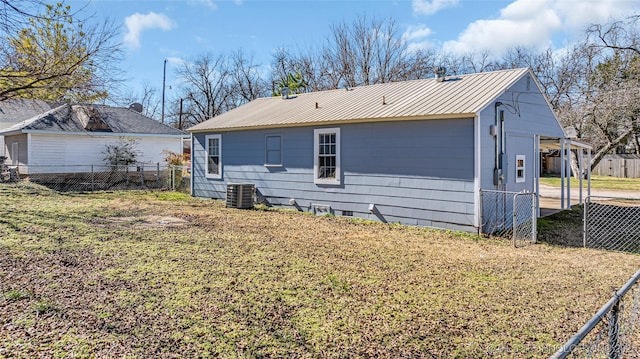 back of property featuring central AC unit and metal roof