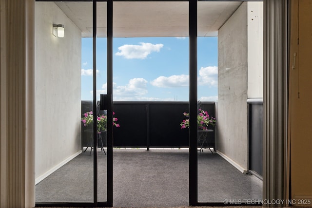 doorway to outside with carpet floors, healthy amount of natural light, baseboards, and floor to ceiling windows