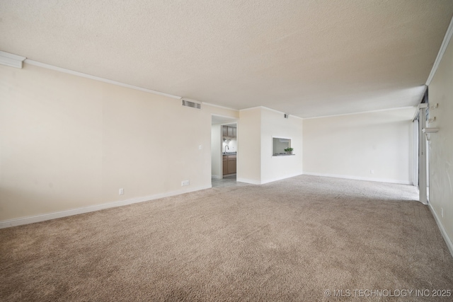 unfurnished living room with carpet, a textured ceiling, ornamental molding, and baseboards