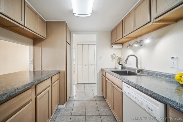 kitchen featuring a sink, white dishwasher, dark countertops, and light tile patterned floors