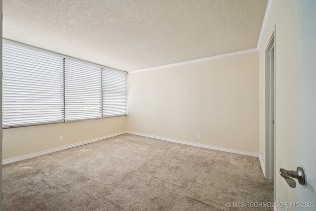 unfurnished room with carpet, a textured ceiling, crown molding, and baseboards