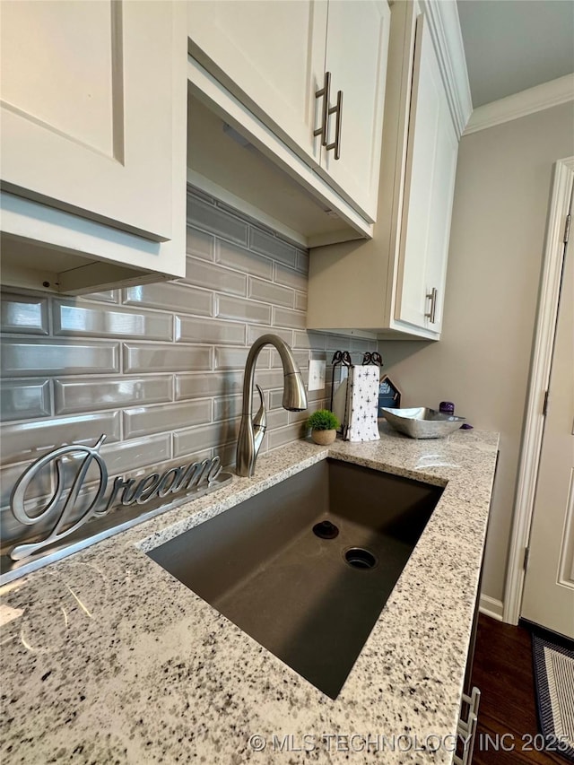 3922 S Norfolk Ave, Tulsa, OK 74105 - kitchen featuring backsplash, ornamental molding, white cabinets, and light stone counters