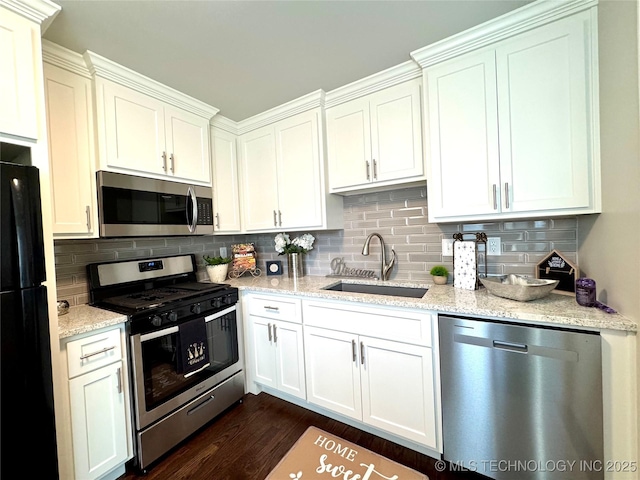 3922 S Norfolk Ave, Tulsa, OK 74105 - kitchen featuring stainless steel appliances, a sink, decorative backsplash, and light stone counters