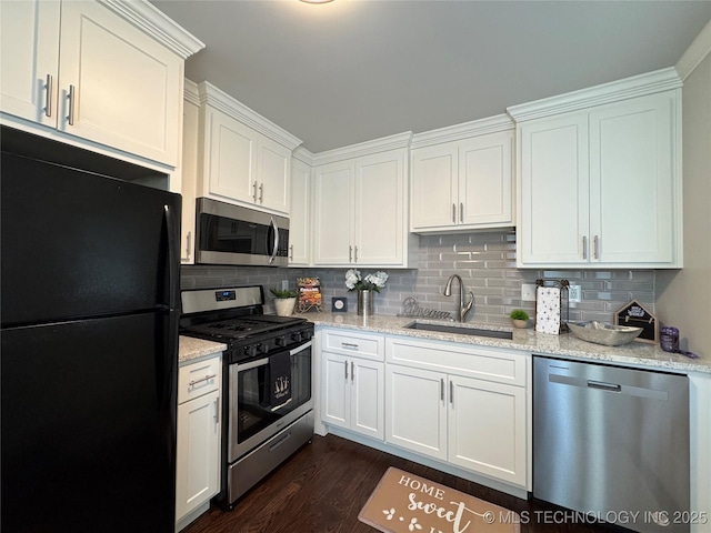 3922 S Norfolk Ave, Tulsa, OK 74105 - kitchen with appliances with stainless steel finishes, a sink, white cabinets, decorative backsplash, and dark wood-style floors